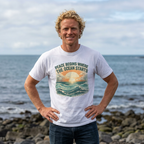 Man wearing ocean sunset graphic t-shirt by the sea Mare Qui Club