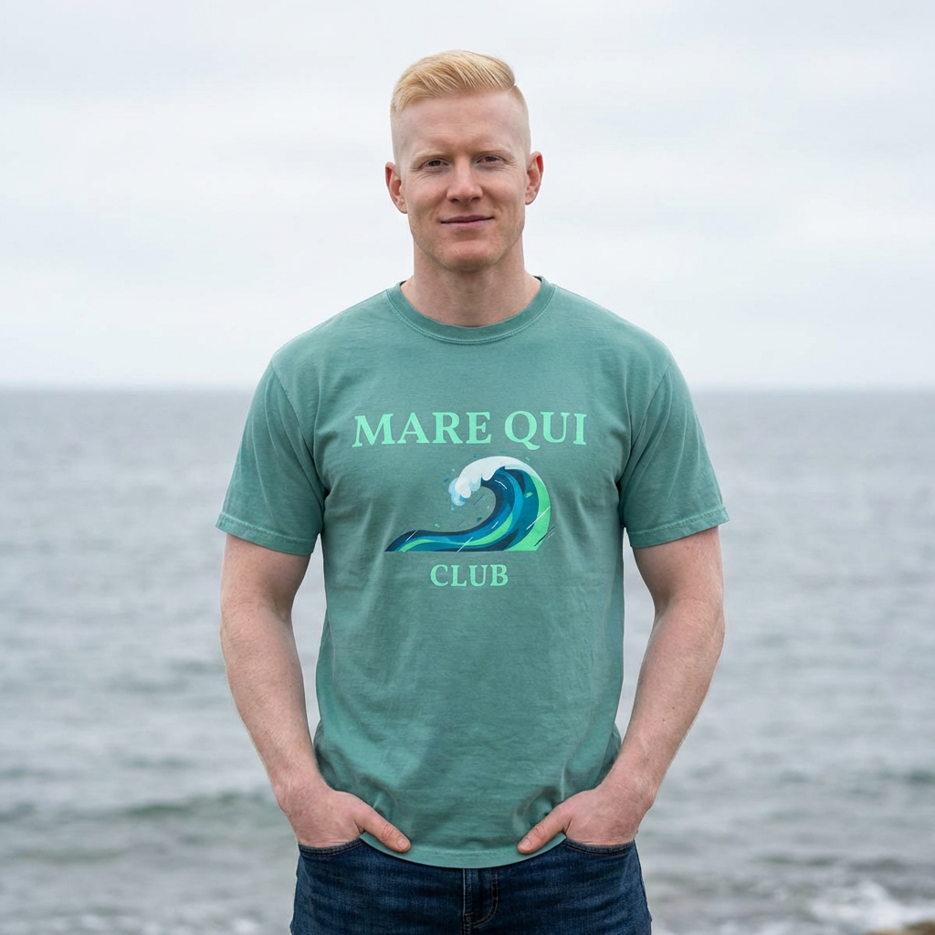 man wearing Mare Qui Club ocean wave graphic t-shirt by the ocean